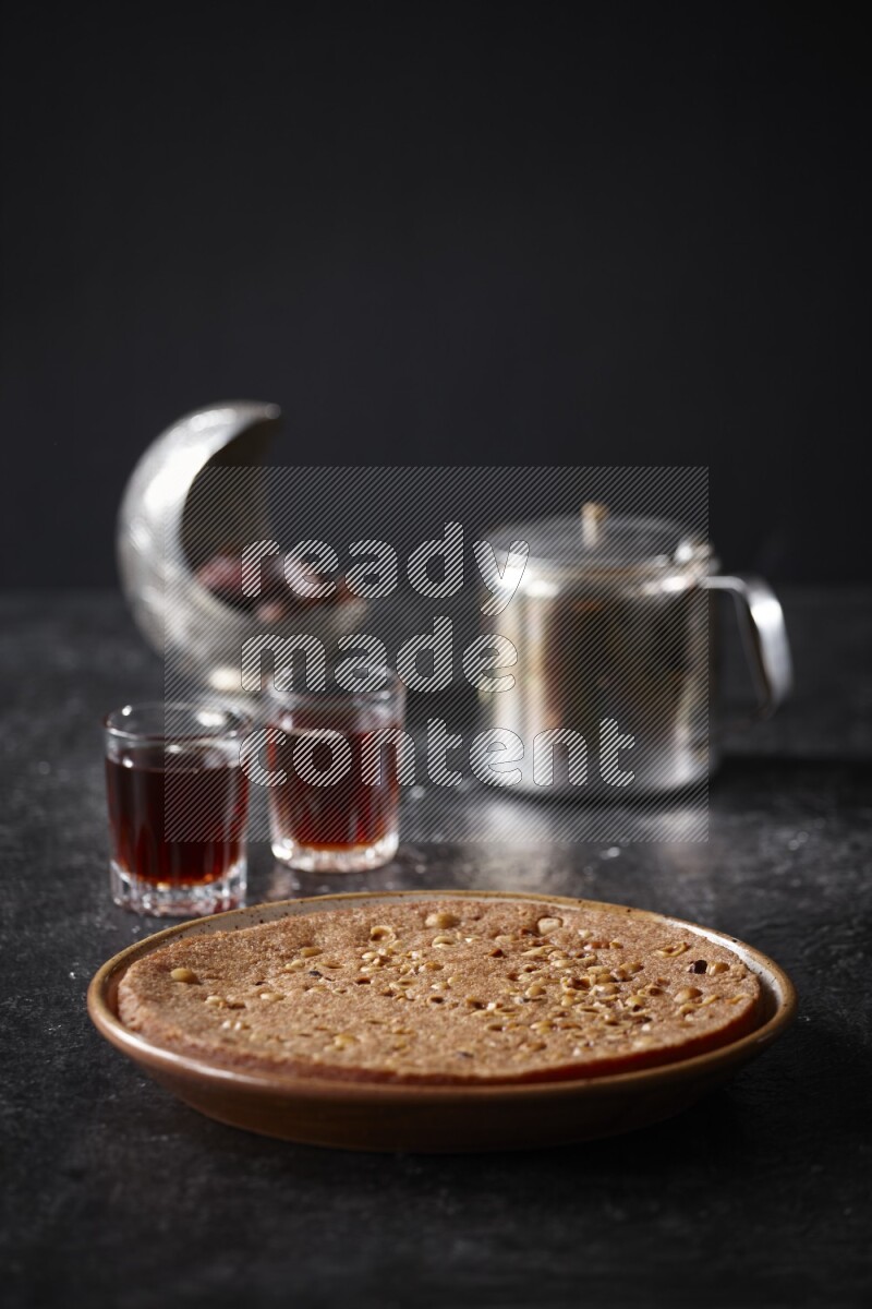 Basbousa with tea in a dark setup