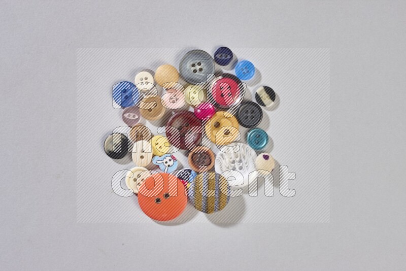 Mixed assorted buttons on grey background