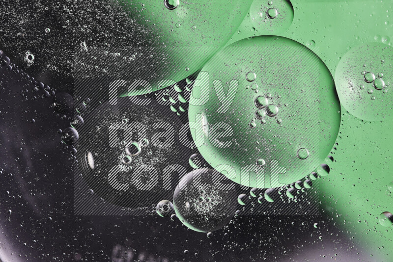 Close-ups of abstract oil bubbles on water surface in shades of black and green