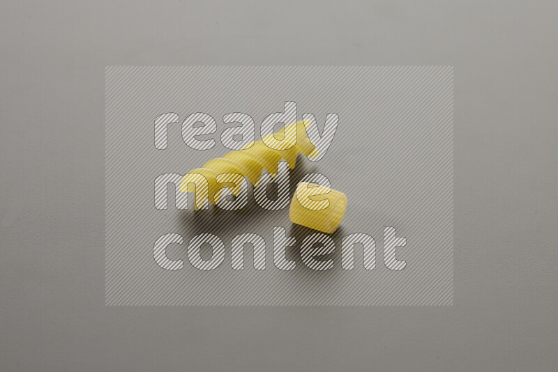 Big rings pasta with other types of pasta on grey background