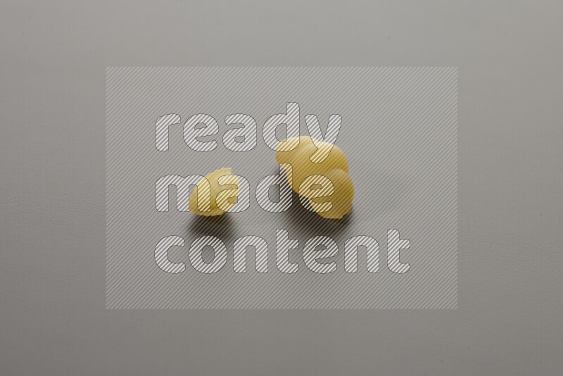 Shells pasta with other types of pasta on grey background