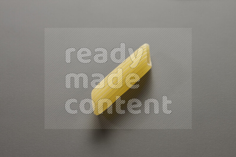 Penne pasta on grey background