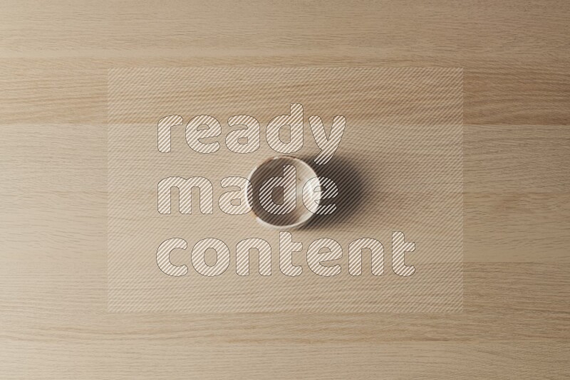 وعاء فخاري متعدد الألوان على خلفية خشبية فاتحة