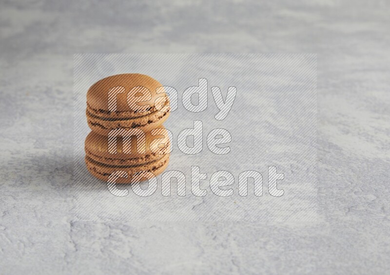 45º Shot of two Brown Coffee macarons  on white  marble background