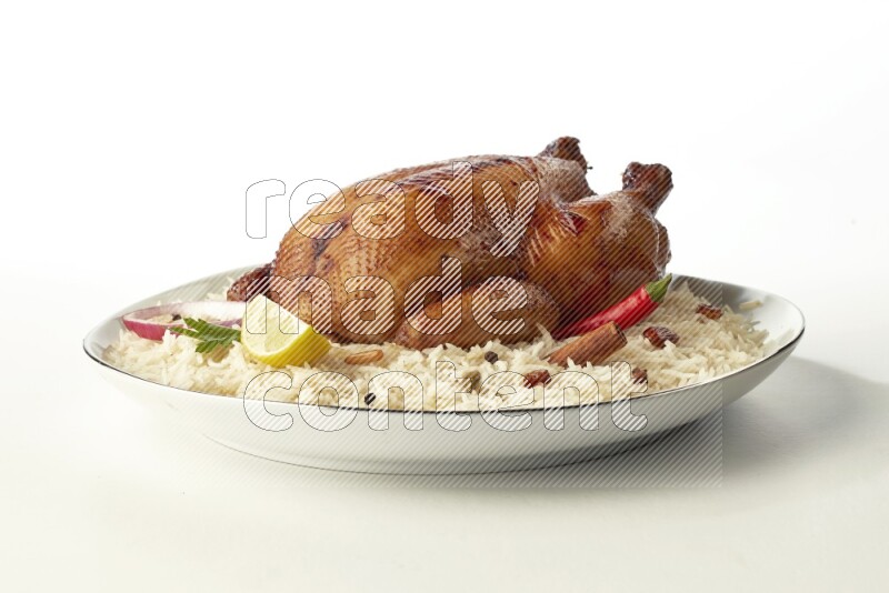 white  basmati Rice with  whole roasted chicken  on a white plate with a silver rim direct  on white background