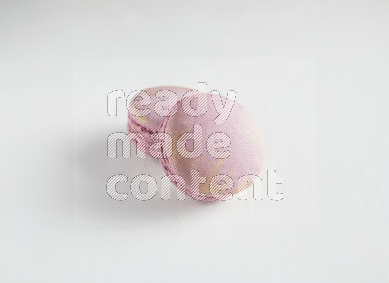 45º Shot of two Purple Strawberry macarons on white background