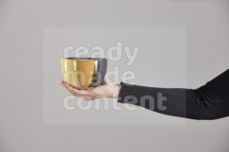 A woman in black abaya holding different pottery essentials in different positions