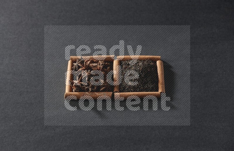 2 squares of cinnamon sticks full of star anise and black tea on black flooring