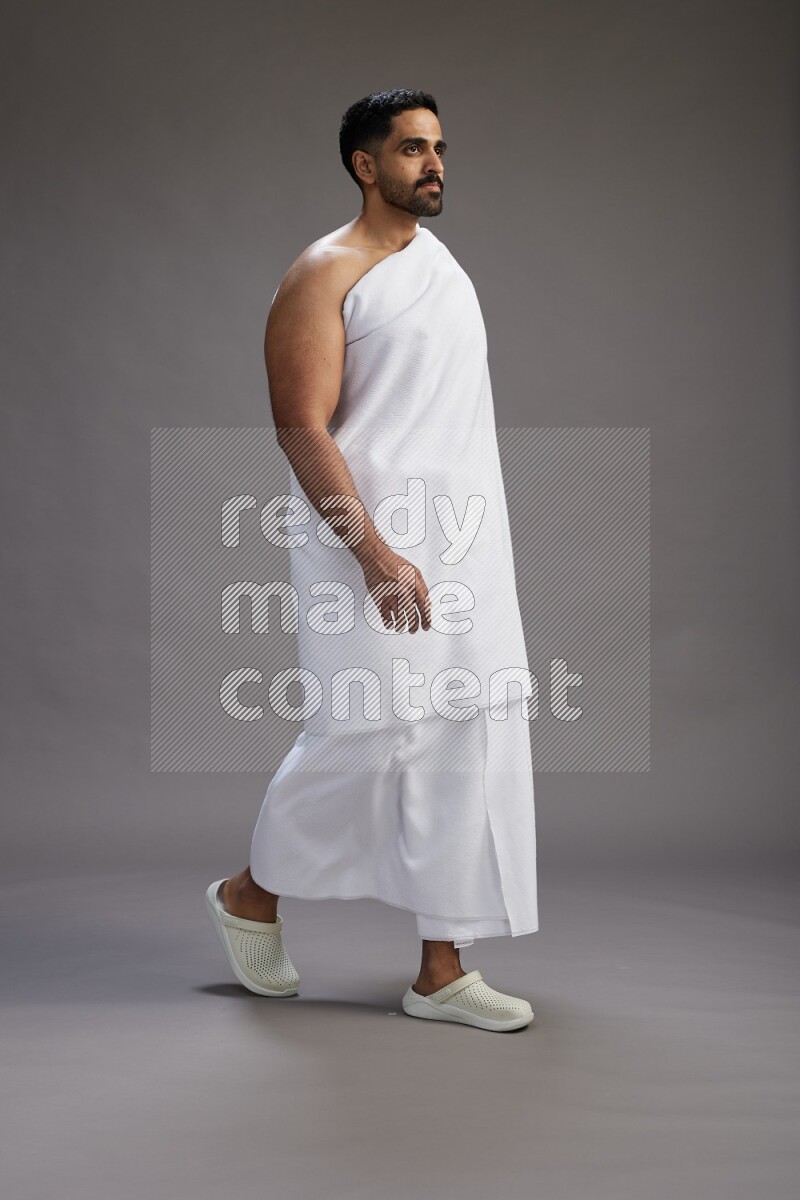 A man wearing Ehram Standing Interacting with the camera on gray background