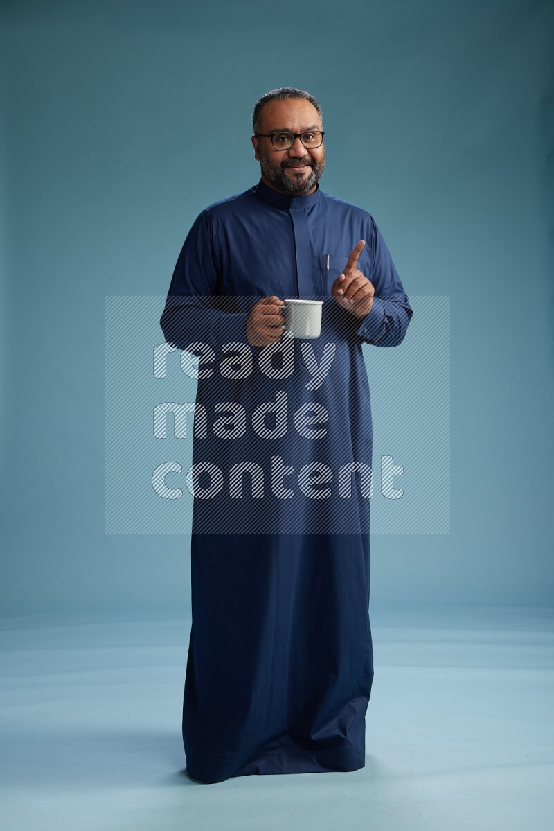 Saudi Man without shimag Standing drinking coffee on blue background