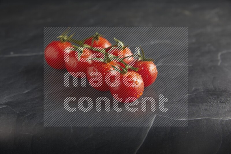 Red cherry tomato vein on a textured black slate background 45 degree