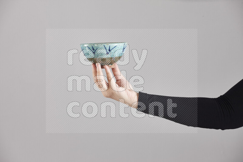 A woman in black abaya holding different pottery essentials in different positions