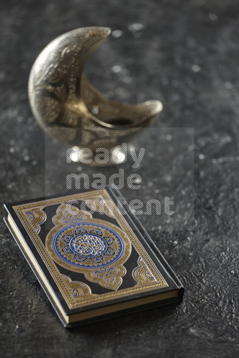 A silver lantern with different drinks, dates, nuts, prayer beads and quran on textured black background