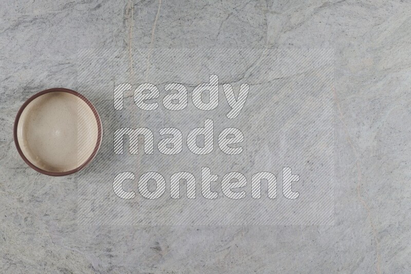 وعاء فرن فخاري متعدد الألوان على خلفية من الرخام الرمادي