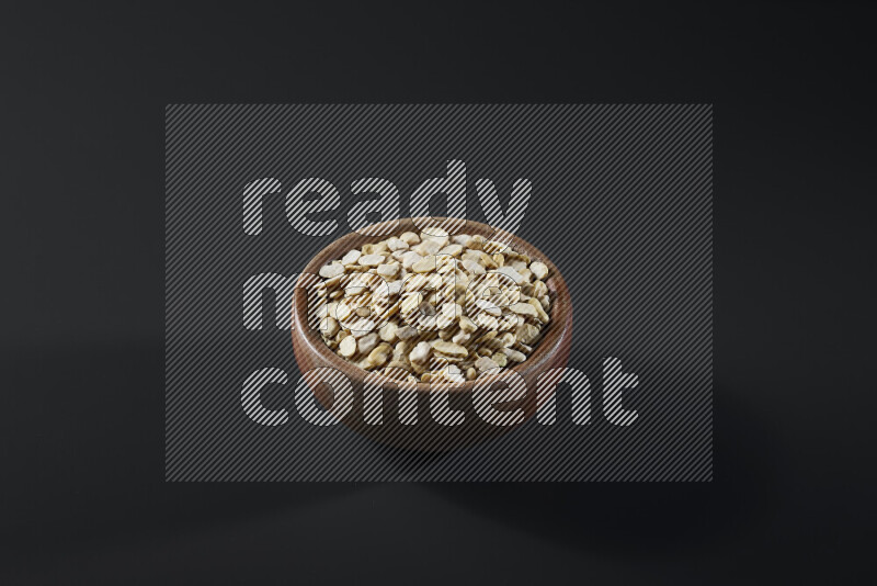 Crushed beans in a wooden bowl on grey background