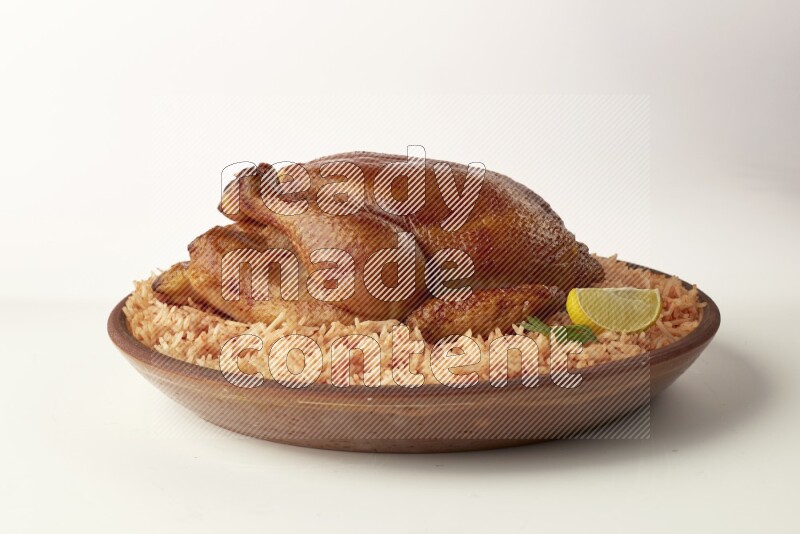 red basmati Rice with whole roasted chicken on a pottery plate direct on white background
