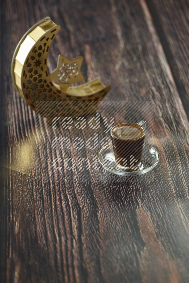 A wooden golden crescent lantern with different drinks, dates, nuts, prayer beads and quran on brown wooden background