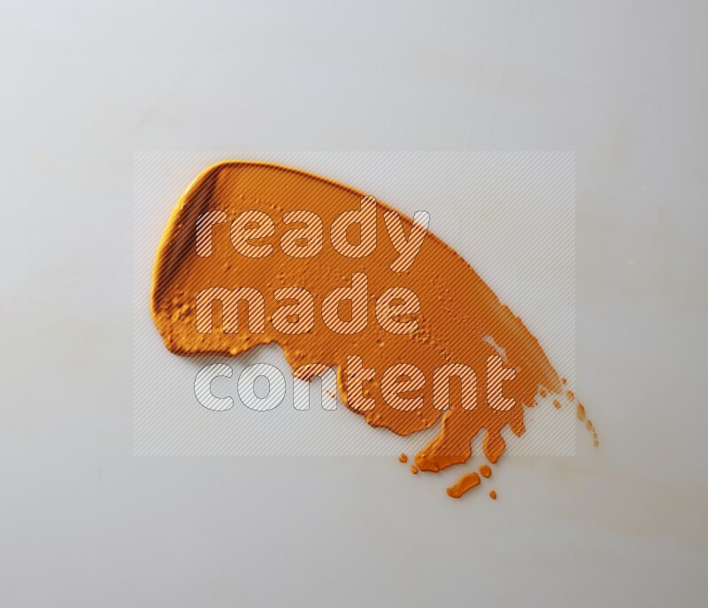 An orange single curved painting knife stroke on white background