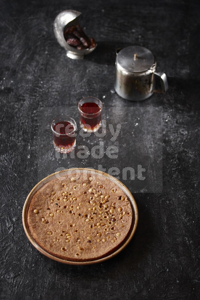 Basbousa with tea in a dark setup