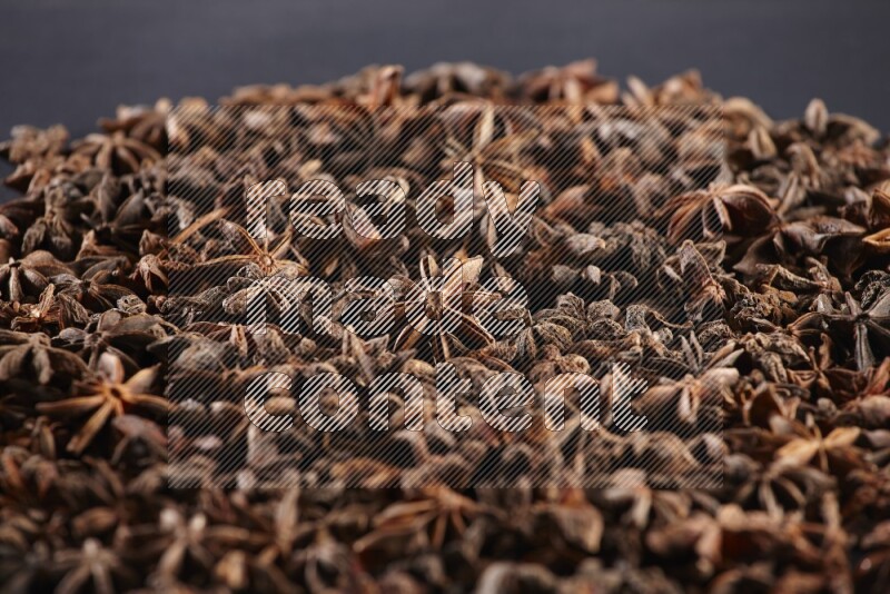 Star Anise herbs fill the frame on black flooring