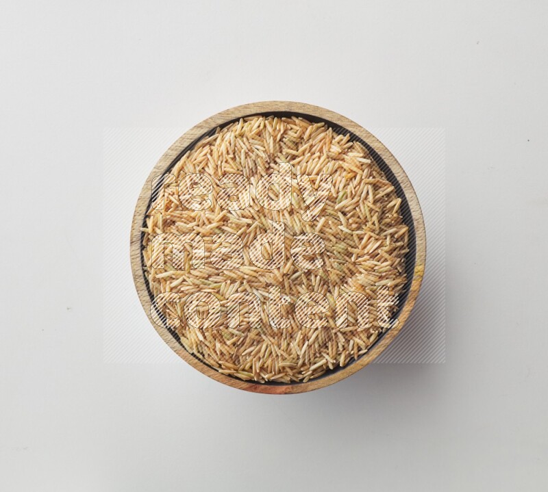 Top-view shot of long grain brown rice in a container on white background