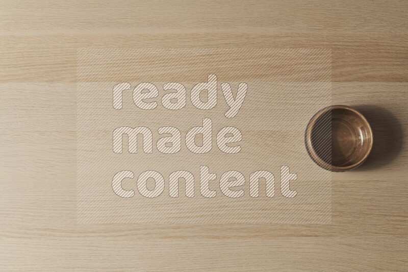 A beige pottery bowl on light wooden background
