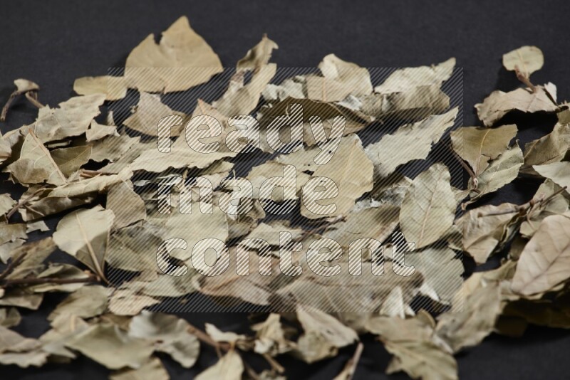 Dried bay leaves on black flooring