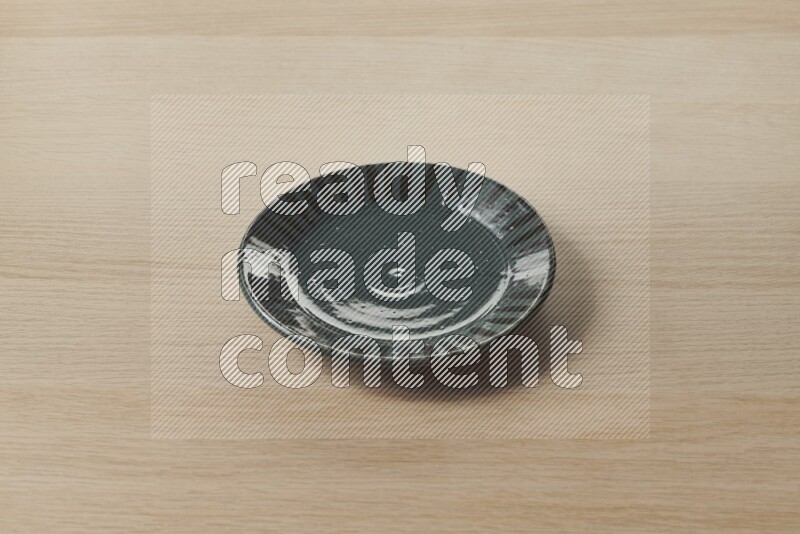 A multicolored pottery plate on light wooden background