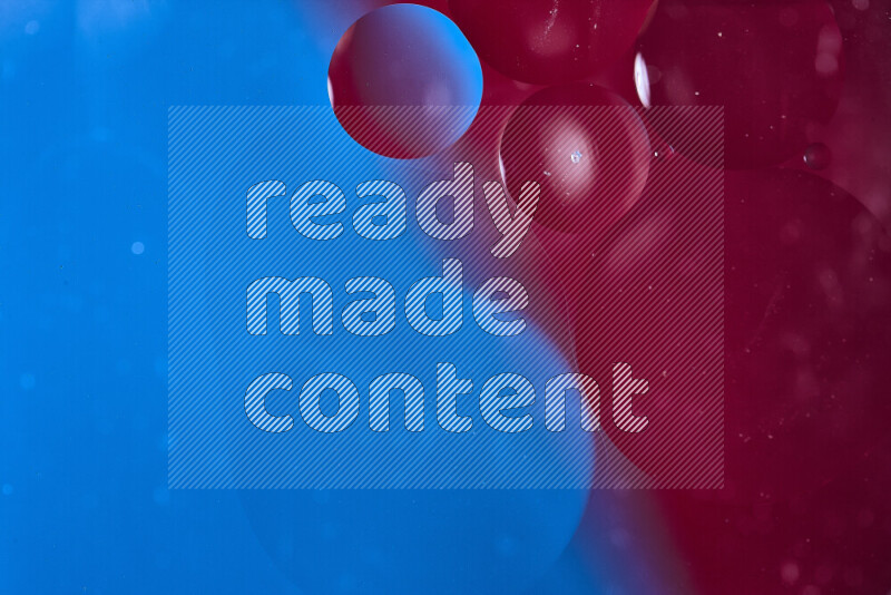 Close-ups of abstract oil bubbles on water surface in shades of blue and red