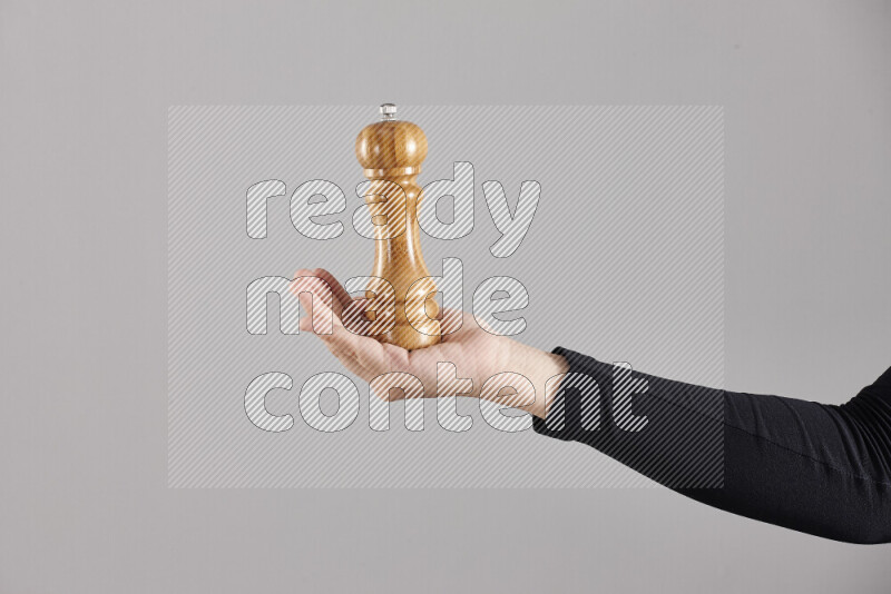 A woman in black abaya holding different wooden essentials in different positions