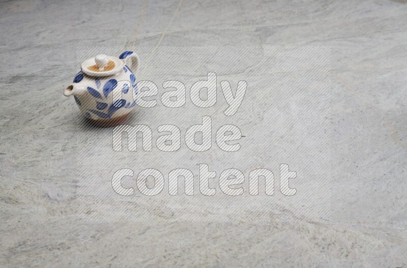 A pottery teapot on grey marble background
