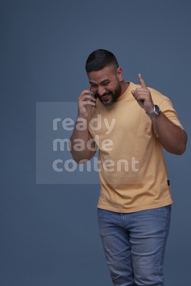 A man Calling on Blue Background wearing Orange T-shirt