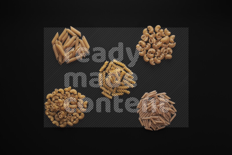 Different pasta types in bunches on black background