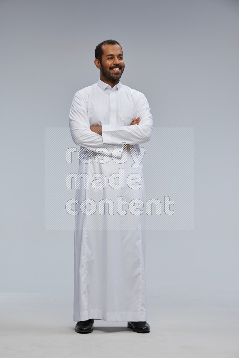 Saudi man wearing Thob standing with crossed arms on Gray background