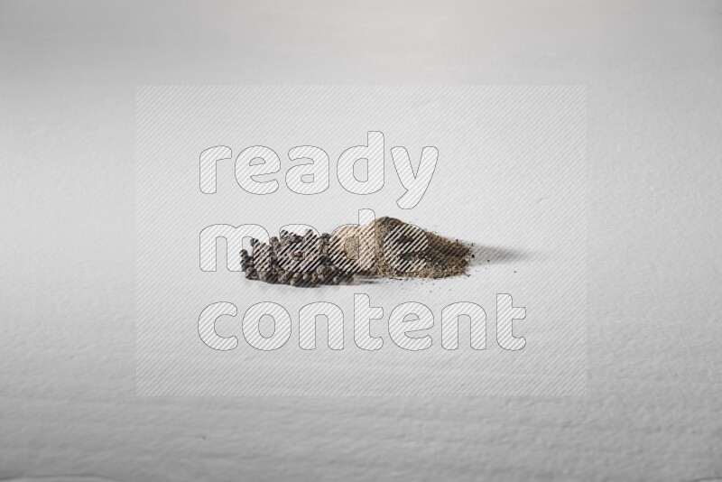 Black pepper powder and beads on a white background