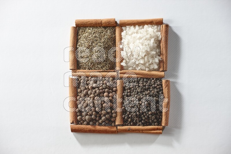 4 squares of cinnamon sticks full of cumin, white salt, allspice and black pepper on white flooring