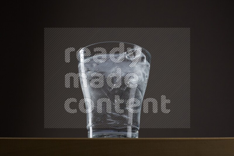 Low angle shot of a glass of water and ice on grey background